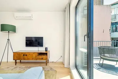 a living room with a tv and a couch at Paraíso E in Porto