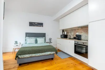 a bedroom with a bed and a kitchen at A Window to Porto - Premium Studio at Clérigos Tower in Porto