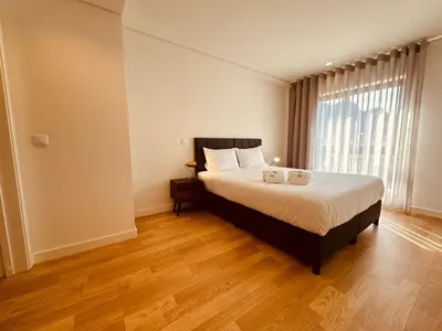 a bedroom with a bed and a large window at Paraíso P in Porto