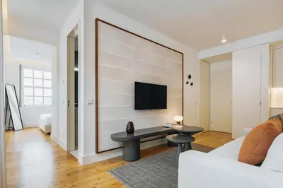 a living room with a couch and a tv on a wall at Feel Porto Clerigos Charm Flats in Porto