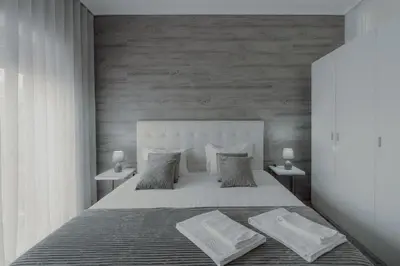 a bedroom with a large bed with two tables at 1BR w/ AC near Palácio de Cristal in Porto