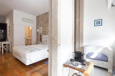 a bedroom with a bed and a table in a room at Trindade Premium Suites & Apartments in Porto