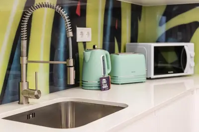 a kitchen counter with a sink and a microwave at GuestReady - Picaria Graffiti in Porto