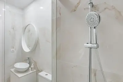 a white bathroom with a shower and a sink at GuestReady - Picaria Graffiti in Porto