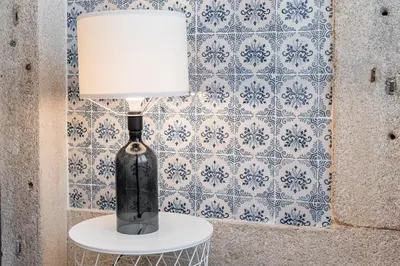 a black vase with a lamp on a table at GuestReady - Picaria Graffiti in Porto
