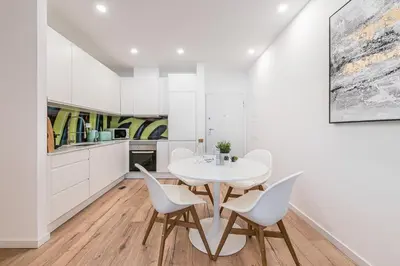 a kitchen and dining room with a white table and chairs at GuestReady - Picaria Graffiti in Porto