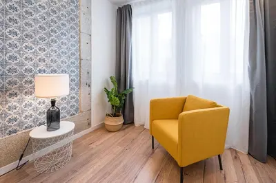 a living room with a yellow chair and a lamp at GuestReady - Picaria Graffiti in Porto
