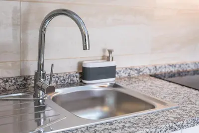 a kitchen sink with a faucet on a counter at GuestReady - Cedofeita Cradle in Porto