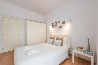 a bedroom with a white bed and a white cabinet at GuestReady - Cedofeita Cradle in Porto
