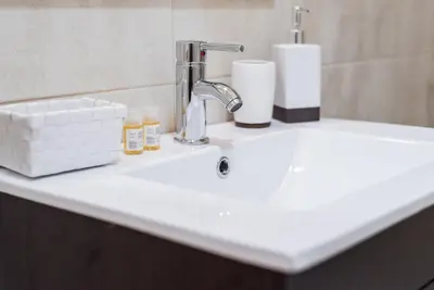 a bathroom sink with a faucet and toiletries on it at GuestReady - Cedofeita Cradle in Porto
