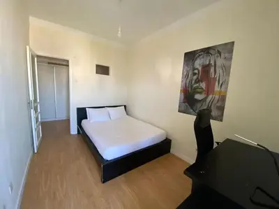 a room with a white bed and a red chair at Casa do Carmo in Porto