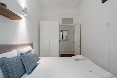 a bedroom with a white bed with blue pillows at Bonfim Apartment by Best2Stay in Porto