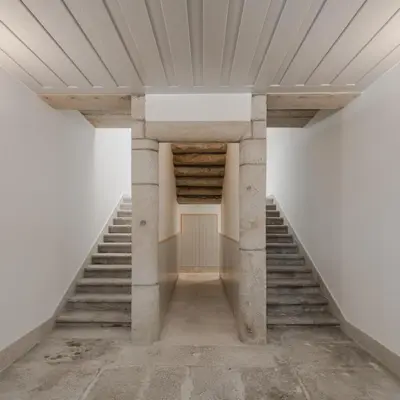 a staircase in a building with stone columns and a wooden ceiling at CL Ildefonso I Apartment in Porto