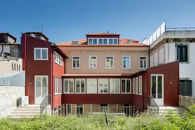 a large red building with stairs in a city at CL Ildefonso I Apartment in Porto