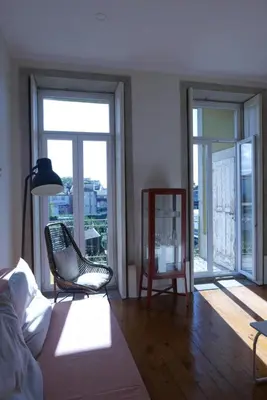 a living room with a couch and a chair and windows at Breiner Apartment, Arts District in Porto
