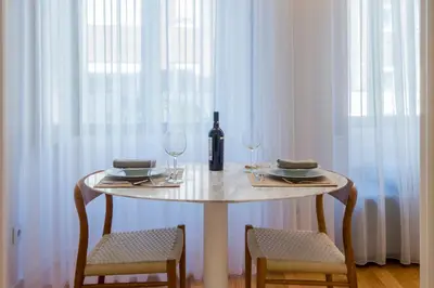 a table with a bottle of wine and two glasses at Domum in Porto
