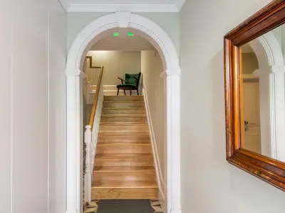 a hallway with an archway and stairs with a chair at Domum in Porto