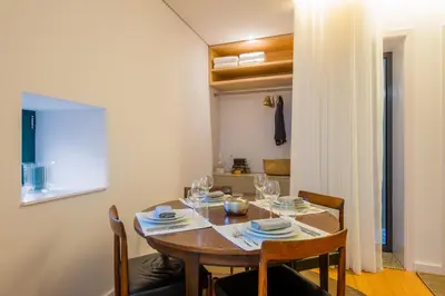 a dining room with a wooden table and chairs at Domum in Porto