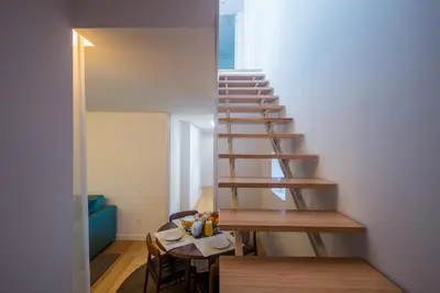 a staircase in a room with a table and chairs at Domum in Porto