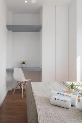 a bedroom with a bed and a desk and a chair at Host Wise - Sunny Bright Flat w Balcony in Porto