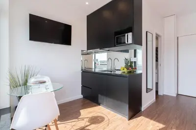 a kitchen with black cabinets and a glass table at Host Wise - Sunny Bright Flat w Balcony in Porto