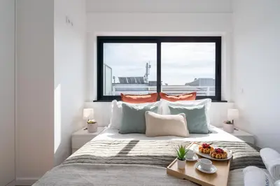 a bedroom with a bed with a tray of food on it at Host Wise - Sunny Bright Flat w Balcony in Porto