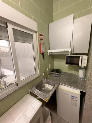 a small kitchen with a sink and a microwave at Antero de Quental Studios 2 in Porto