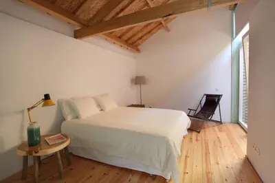 a bedroom with a white bed and a wooden floor at Wood & Blue House - Porto in Porto