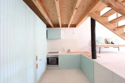 a kitchen with white walls and a wooden ceiling at Wood & Blue House - Porto in Porto