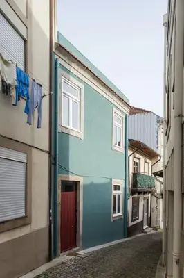 a blue building with a red door on a street at Wood & Blue House - Porto in Porto