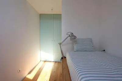a bedroom with a bed with a lamp next to it at Wood & Blue House - Porto in Porto