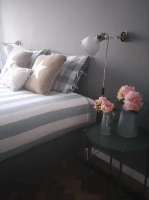 a bed with two vases with flowers on a table at Lulapartment III in Porto