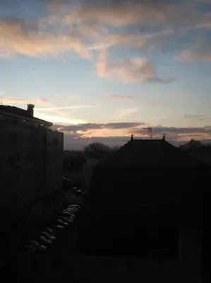 a sunset in a city with buildings and the sky at Lulapartment III in Porto