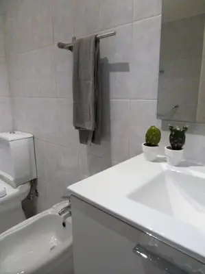 a bathroom with a sink and a toilet and a mirror at Lulapartment III in Porto