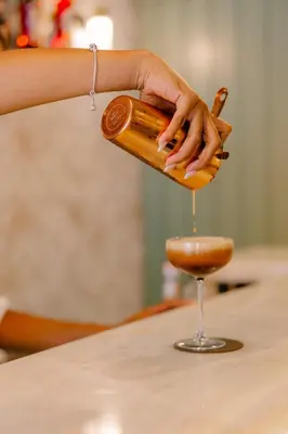 a person pouring a drink into a wine glass at Casa Zogbi Hotel in Porto