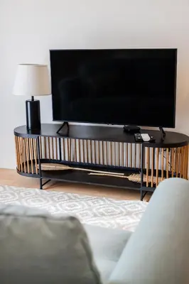 a living room with a couch and a tv and a table at Porto Living | 1BR Flat with AC in Porto