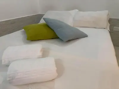 a white bed with pillows and towels on it at Lapa 274 Studio in Porto