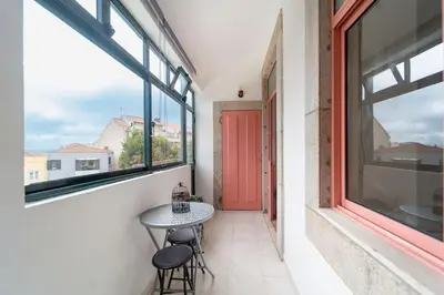 a balcony with a table and two stools at The Charm Bonfim OPO in Porto