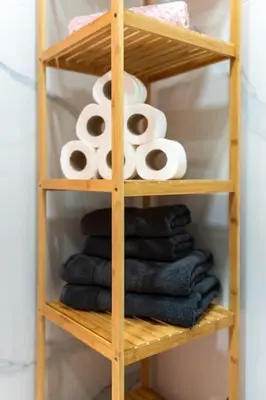 a wooden shelf with rolls of toilet paper and towels at The Charm Bonfim OPO in Porto