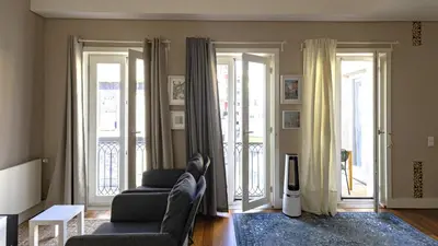 a living room with two chairs and sliding doors at Cardosas Spacious Studio by LovelyStay in Porto