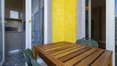 a dining room with a wooden table and yellow tiles at Cardosas Spacious Studio by LovelyStay in Porto