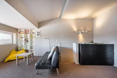 a living room with a black couch and a table at GuestReady - A charming duplex home near Boavista in Porto