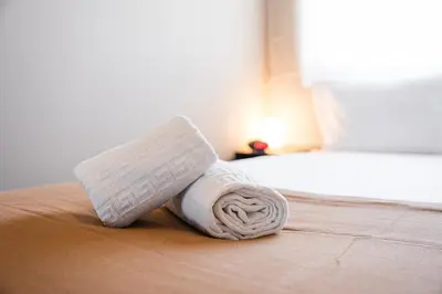a white towel on the floor next to a bed at GuestReady - A charming duplex home near Boavista in Porto