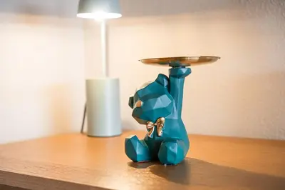 a blue glass vase with a tray on a table at GuestReady - A charming duplex home near Boavista in Porto