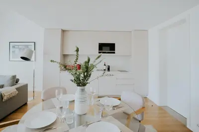 a white dining room with a table and chairs at VIVA Formosa Lofts in Porto
