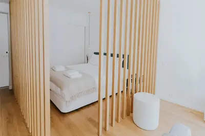 a bedroom with a white bed and a wooden wall at VIVA Formosa Lofts in Porto