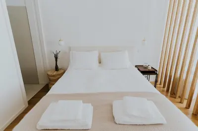 a bedroom with a large white bed with two towels on it at VIVA Formosa Lofts in Porto
