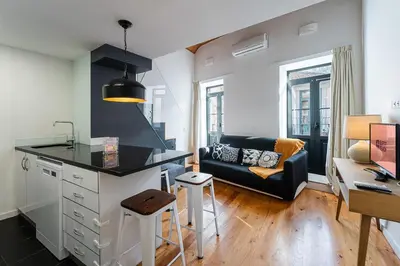 a kitchen and living room with a couch and a table at GuestReady - Charming Mezzanine near Porto in Vila Nova de Gaia