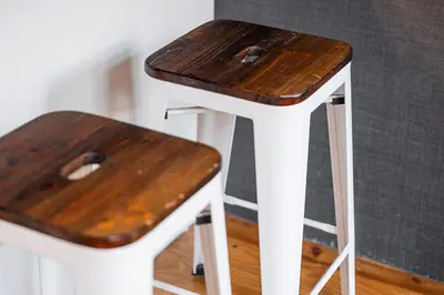 a wooden stool with a wooden table and a bench at GuestReady - Charming Mezzanine near Porto in Vila Nova de Gaia