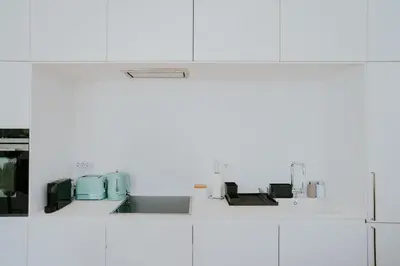 a kitchen with white cabinets and a sink at VIVA Contemporary Duque Terceira in Porto